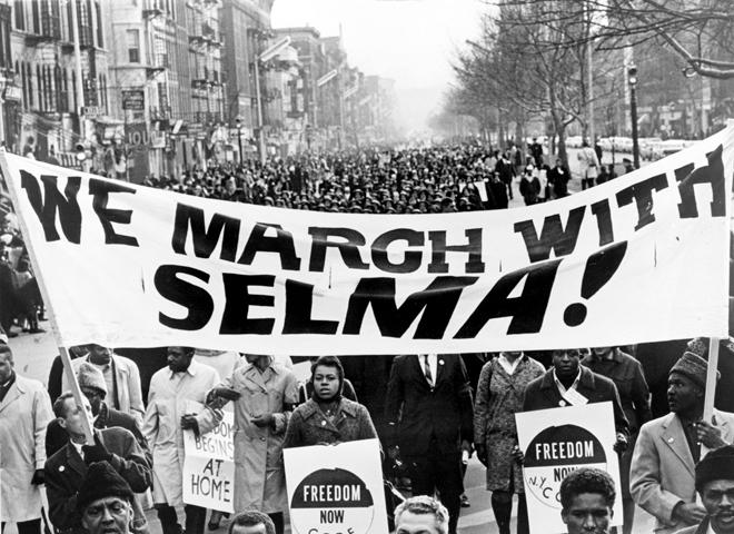 Marchers carrying banner We march with Selma! on street in Harlem, New York City, New York.