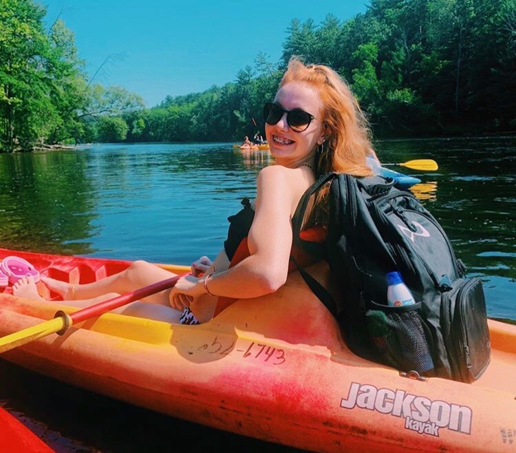 Sophomore Ashlynn Lambert sails down an aquamarine lake in her vivid orange kayak
