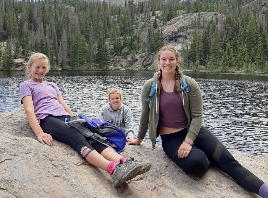 Ellie+Latunski+and+her+sisters+on+a+family+vacation%2C+taking+a+picture+together+mid+hike.