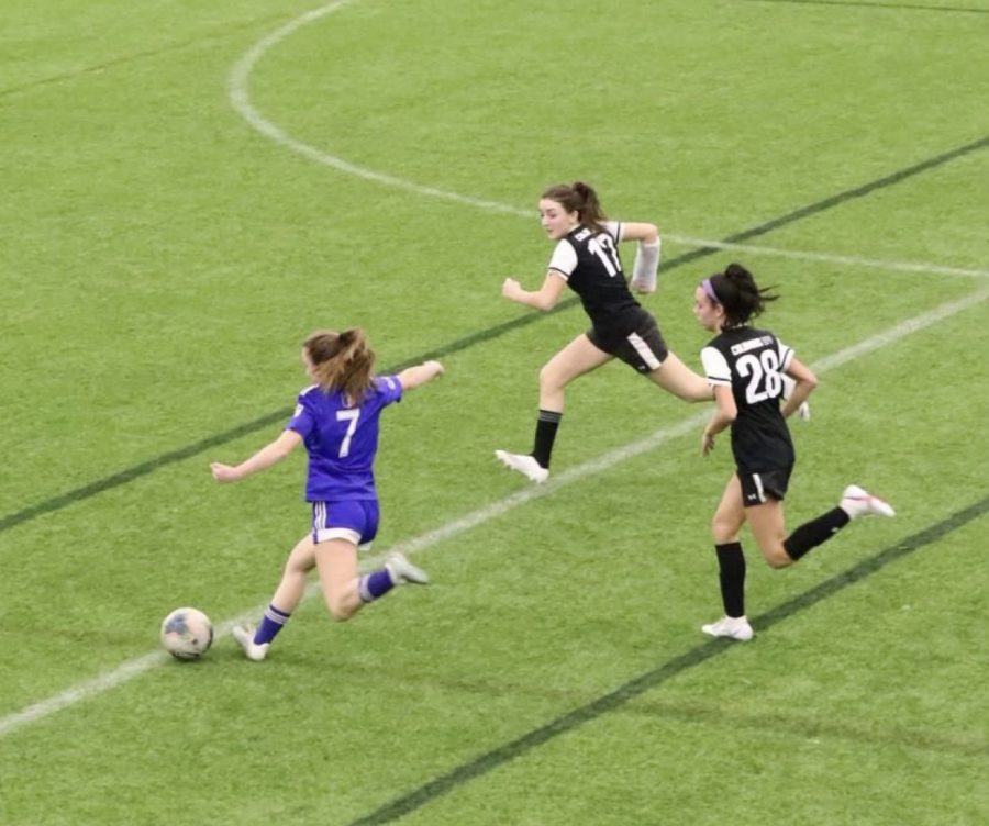 Number 7, Haley Ward, kicks the soccer ball.