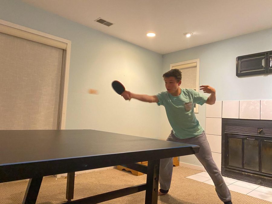 Logan Mix practices ping pong in his basement with his father.