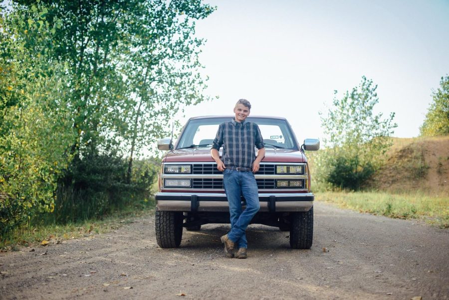 Senior Seth Bush posing in front of his pick-up truck 