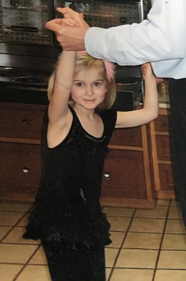 Young me dancing in the kitchen with my dad after putting on my favorite outfit.