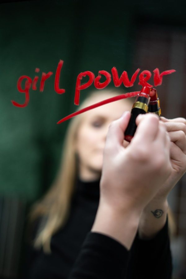 Girl Power is written in red lipstick on a mirror in an act of passion for womans rights.