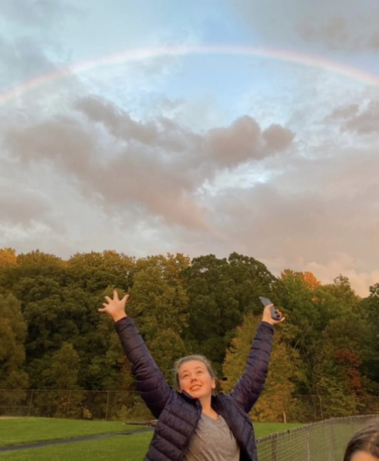 A picture of my sister in front of a rainbow