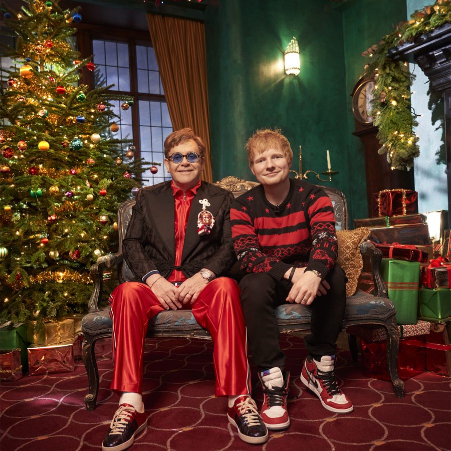 Ed Sheeran and Elton John posing among the Christmas decor. 