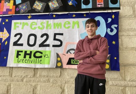 Freshman Thomas Paplawsky standing in front of the freshmen Homecoming banner