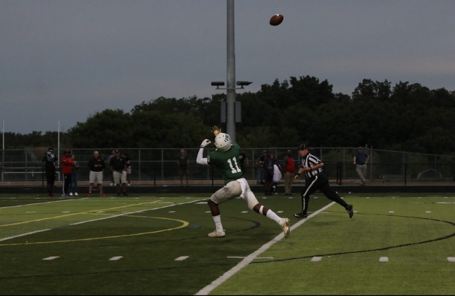 Senior Conner Milton catching a pass from a teammate on the football field.