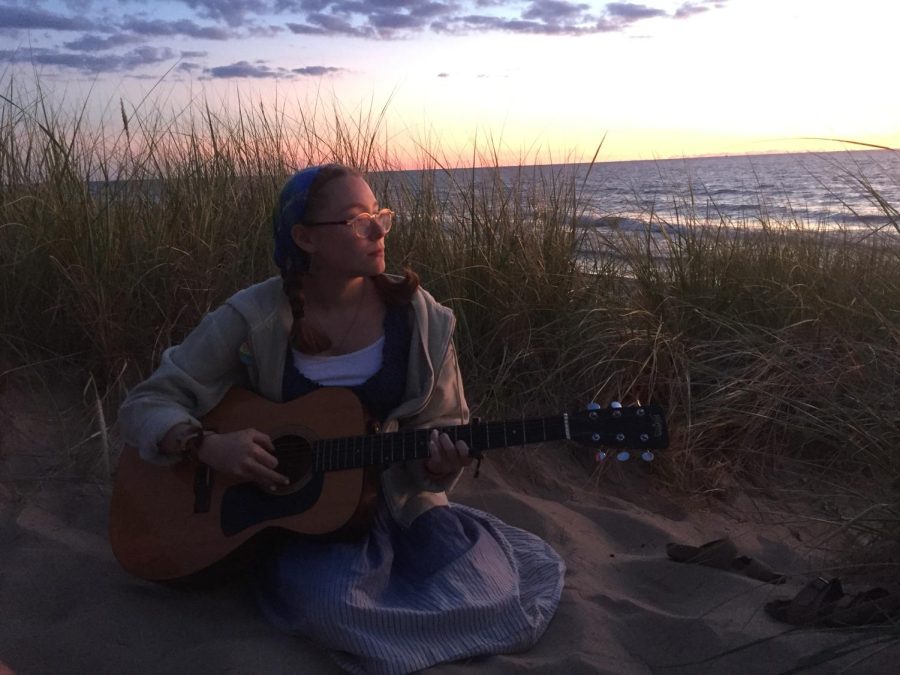 Madie%2C+during+sunset%2C+playing+the+guitar+on+a+grassy+beach.