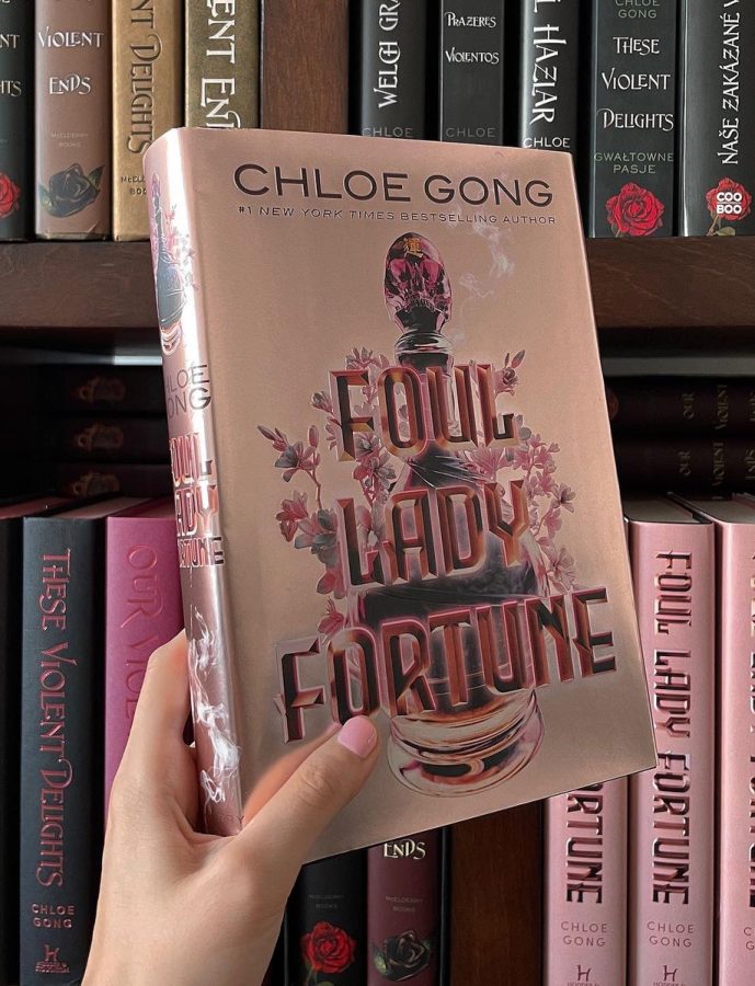 Foul Lady Fortune in front of a shelf of editions of Chloe Gongs other works