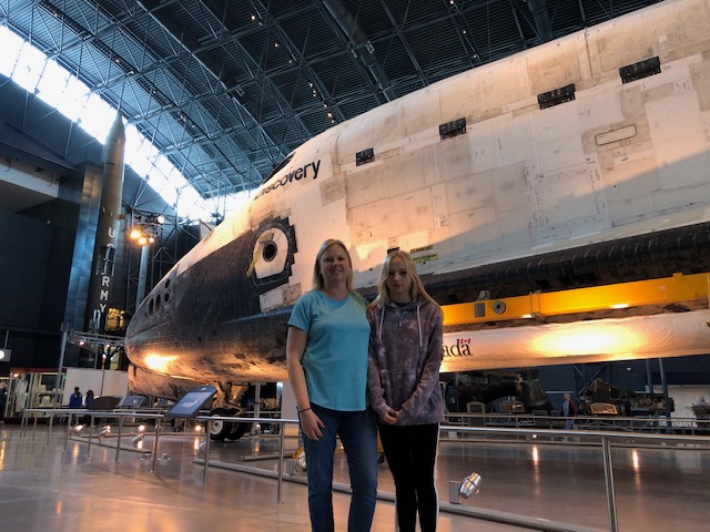 Physics teacher Amy Stone with her daughter Ellie Stone by the Space Shuttle Discovery at the National Air and Space Museum