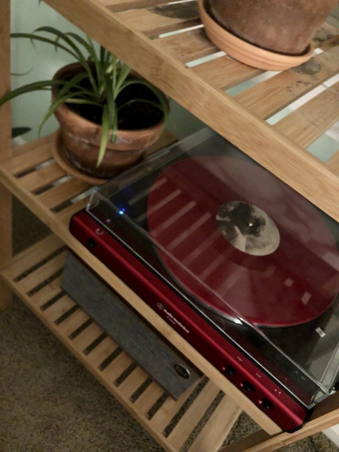My stunning little turntable in cherry red, featuring a matching vinyl record: folklore, by Taylor Swift