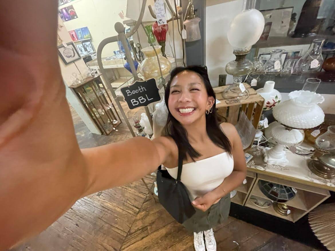 Kayla Quach smiles for a .5 selfie at an antique warehouse.