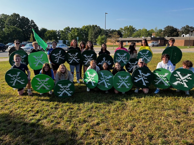 A group of students in the Green Empire pose with their battle shields.