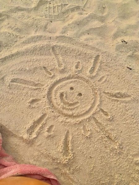 a cute sun drawn into the sand