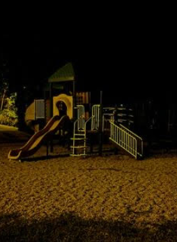 An empty playground, reminiscent of the one we used to play on. Now shrouded by the darkness of night and passing time.